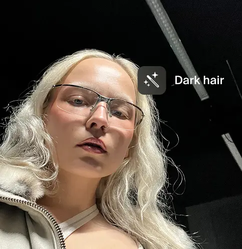 A pixelated image of an orange and white cat lying down, looking to the side, with blurred greenery in the background